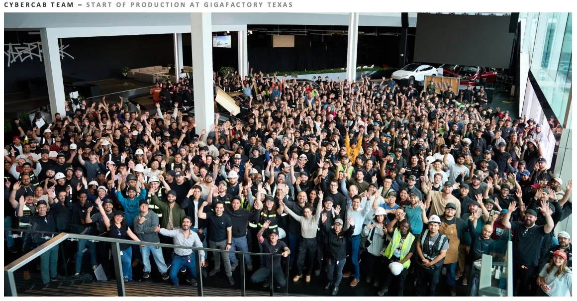 Large factory team standing in front of a Cybercab production sign.